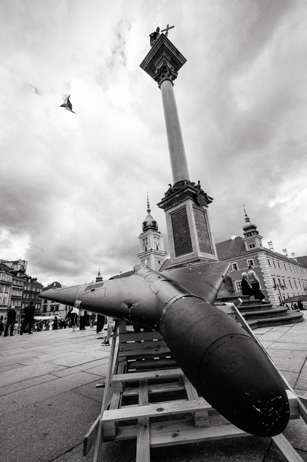 A Shahed drone is seen displayed on a wooden pallet in front of Warsaw's Royal Castle on the occasion of Ukrainian Independence Day. A bird flies in the sky.